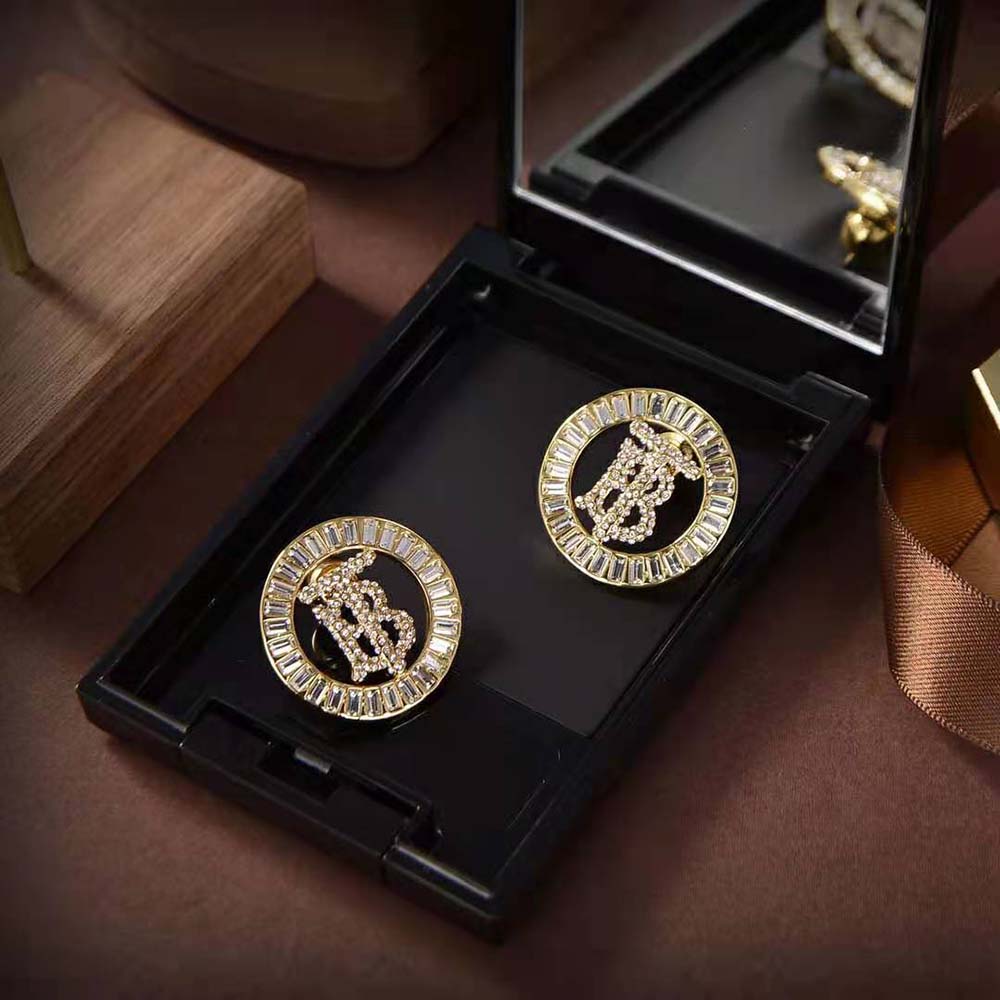 Side angle showing size and push-back closure of Burberry gold earrings