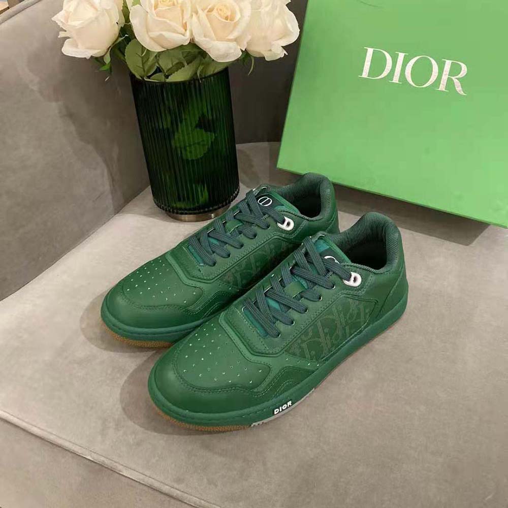 Close-up of embossed Dior logo on green leather sneaker