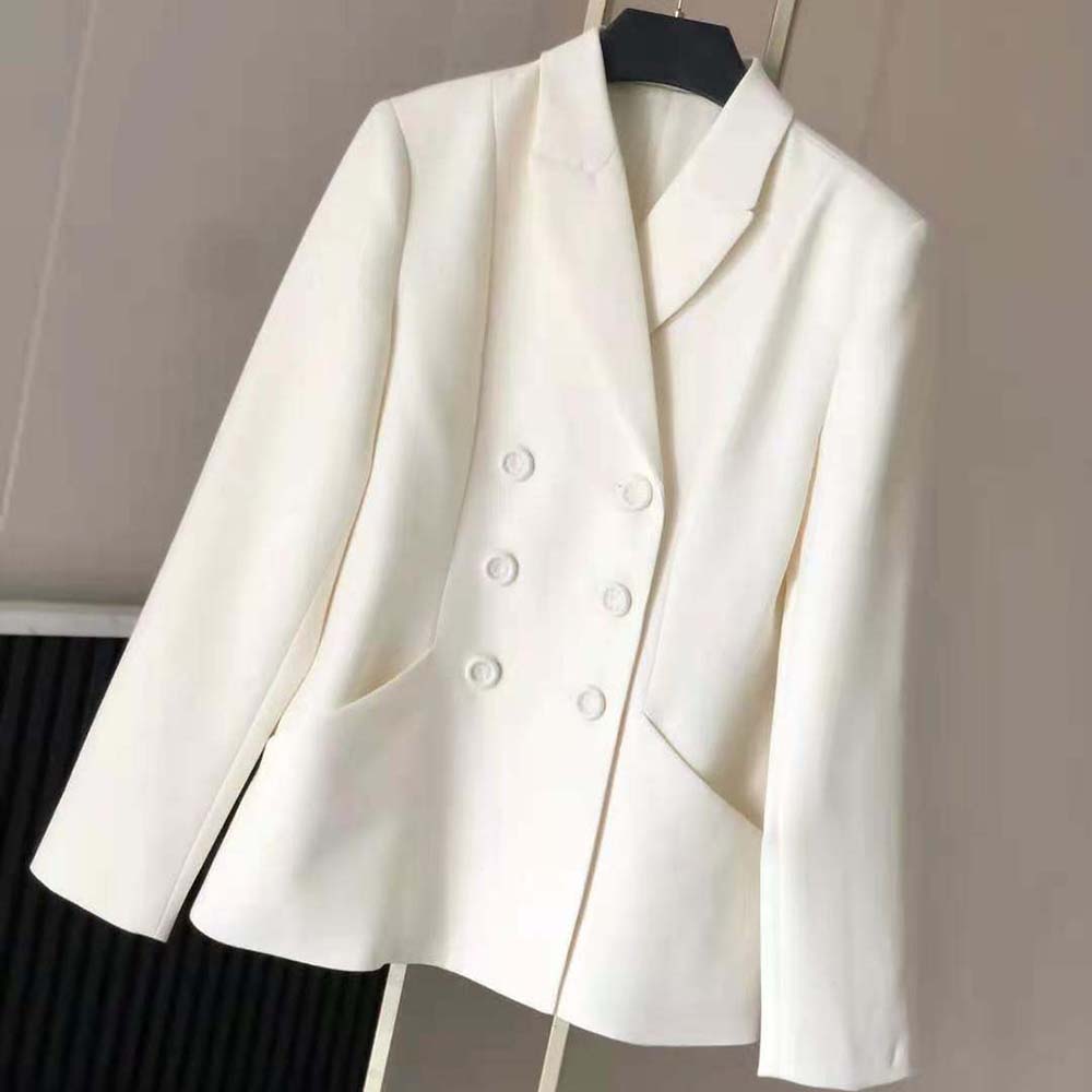 Close-up of signature Dior metal buttons on the white wool and silk jacket