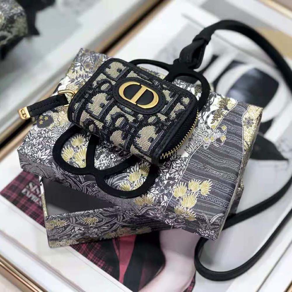 Close-up on silver Dior hardware detail on phone cover and AirPods Pro case