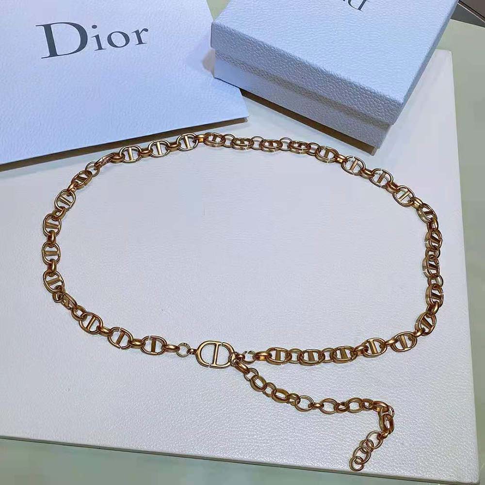 Close-up detail of Dior chain link on gold-finish metal belt