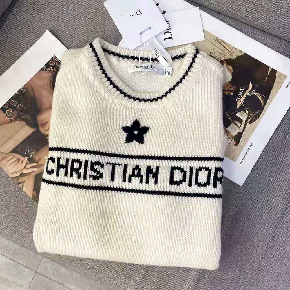Close-up detail of Dior embossed signature on white cashmere wool sweater