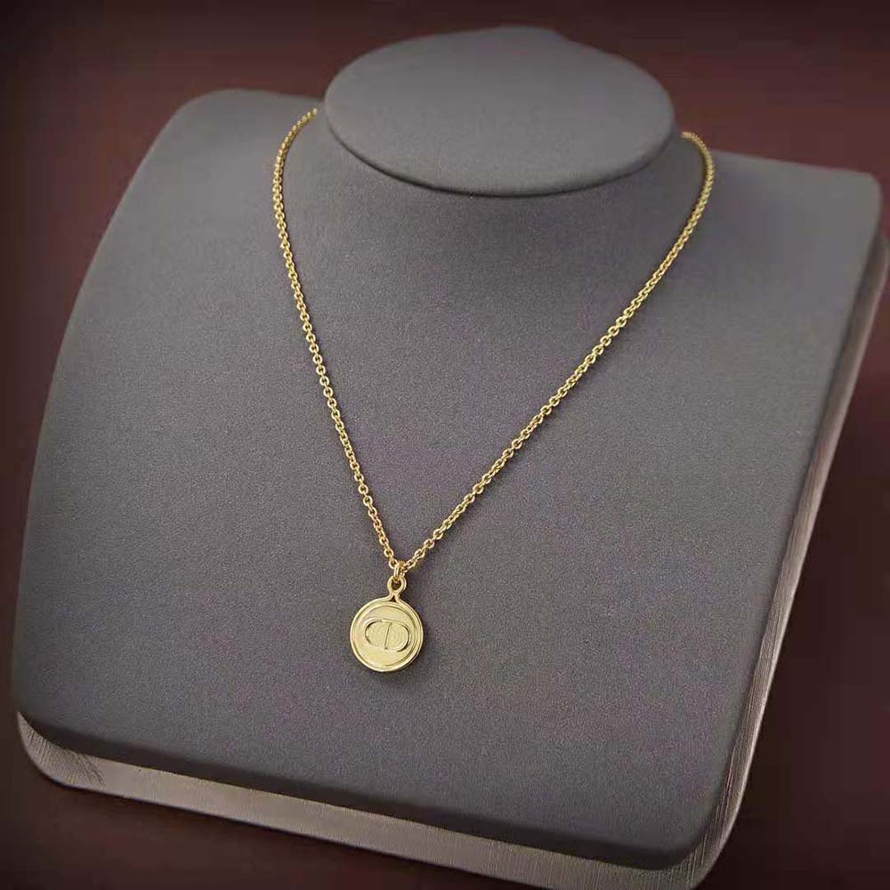 Close-up detail of Dior Women Petit CD Necklace gold-finish signature CD pendant