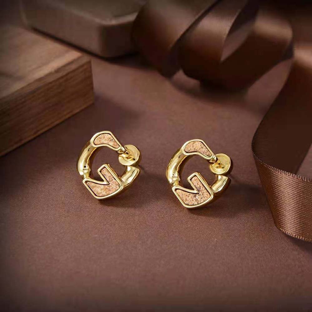 Close-up detail of chain-link and signature G hardware on earrings