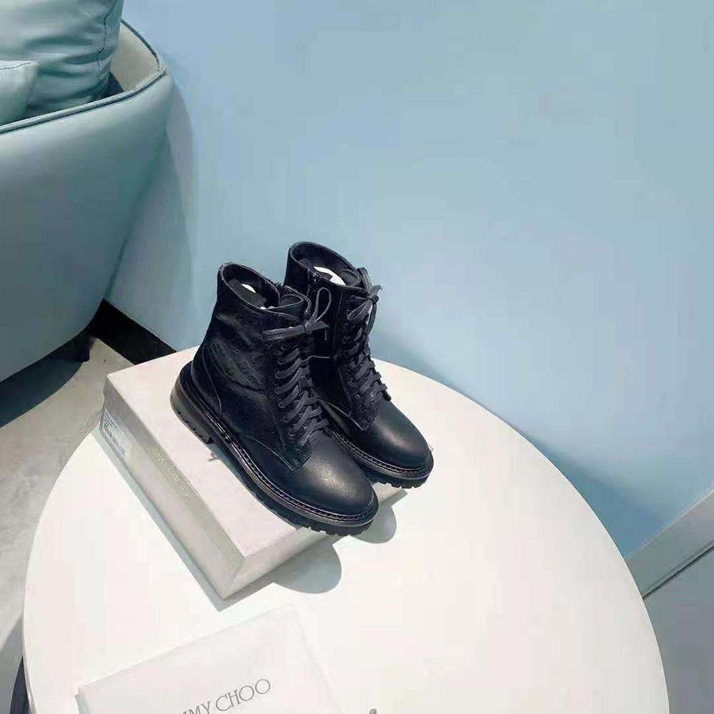 Close-up of silver JC monogram hardware on Jimmy Choo Cora Flat combat boots