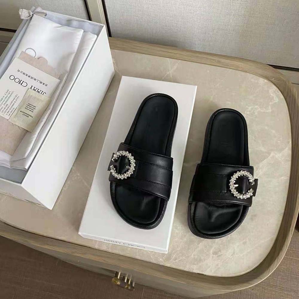 Close-up of crystal buckle detail on Jimmy Choo Fallon black leather slides