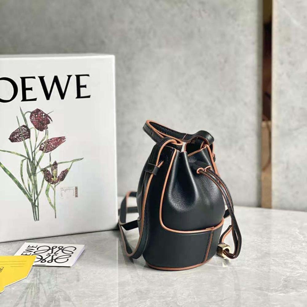 Side profile showing compact shape of Loewe Women Nano Balloon Bag in black