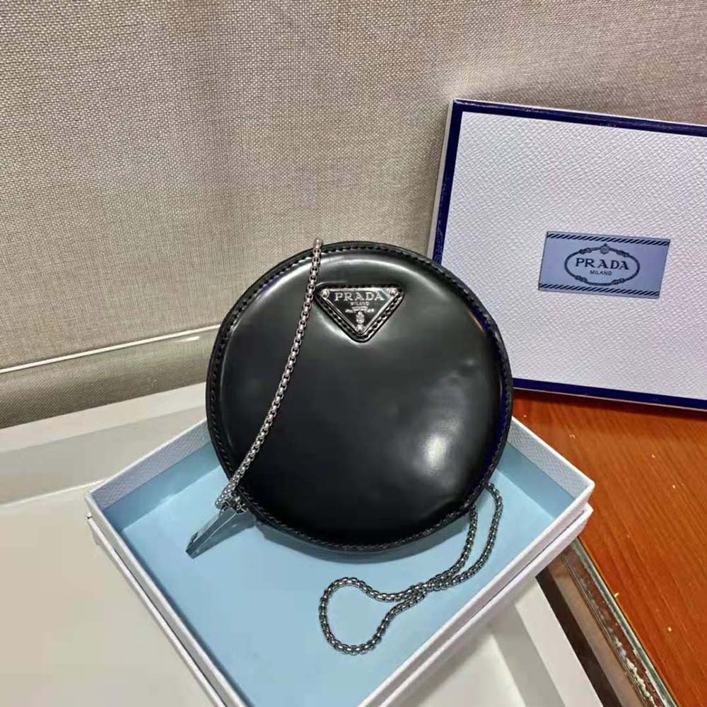 Close-up of brushed leather texture and silver-tone Prada logo on mini-pouch