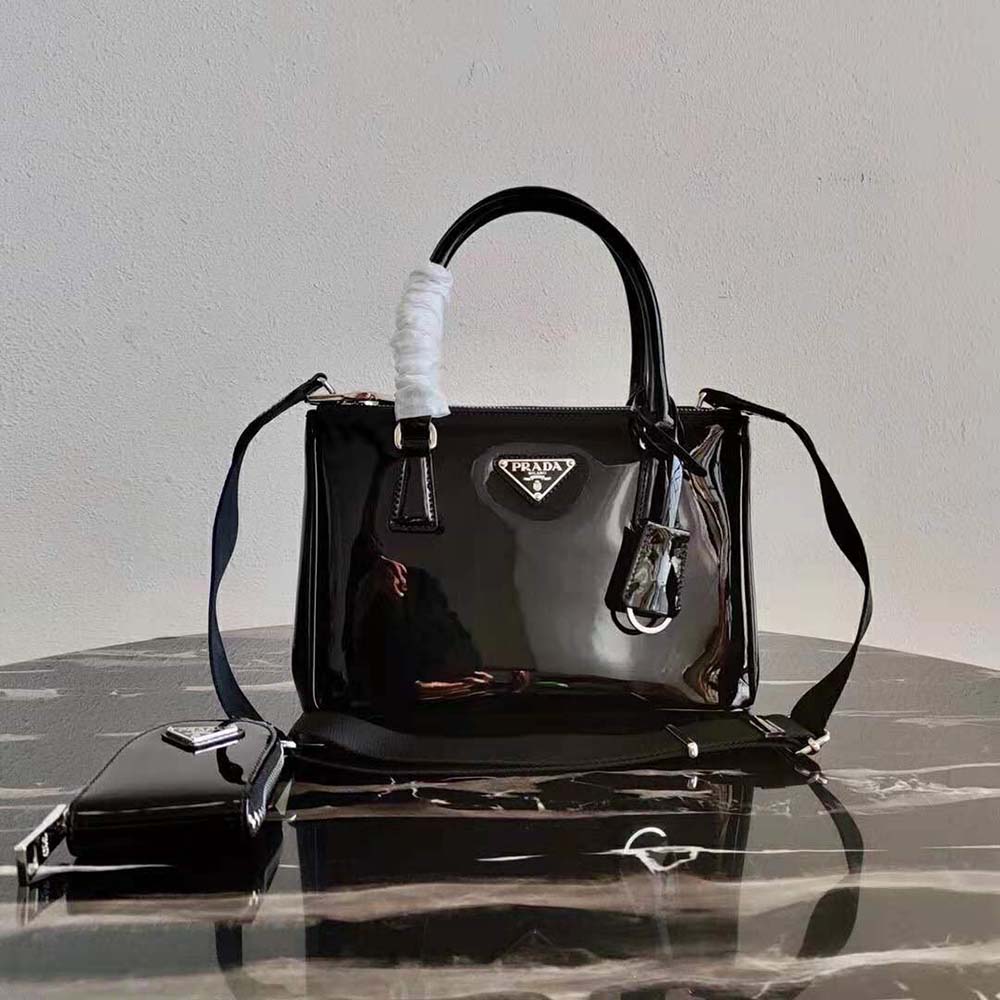 Close-up of gold Prada logo on brushed leather bag