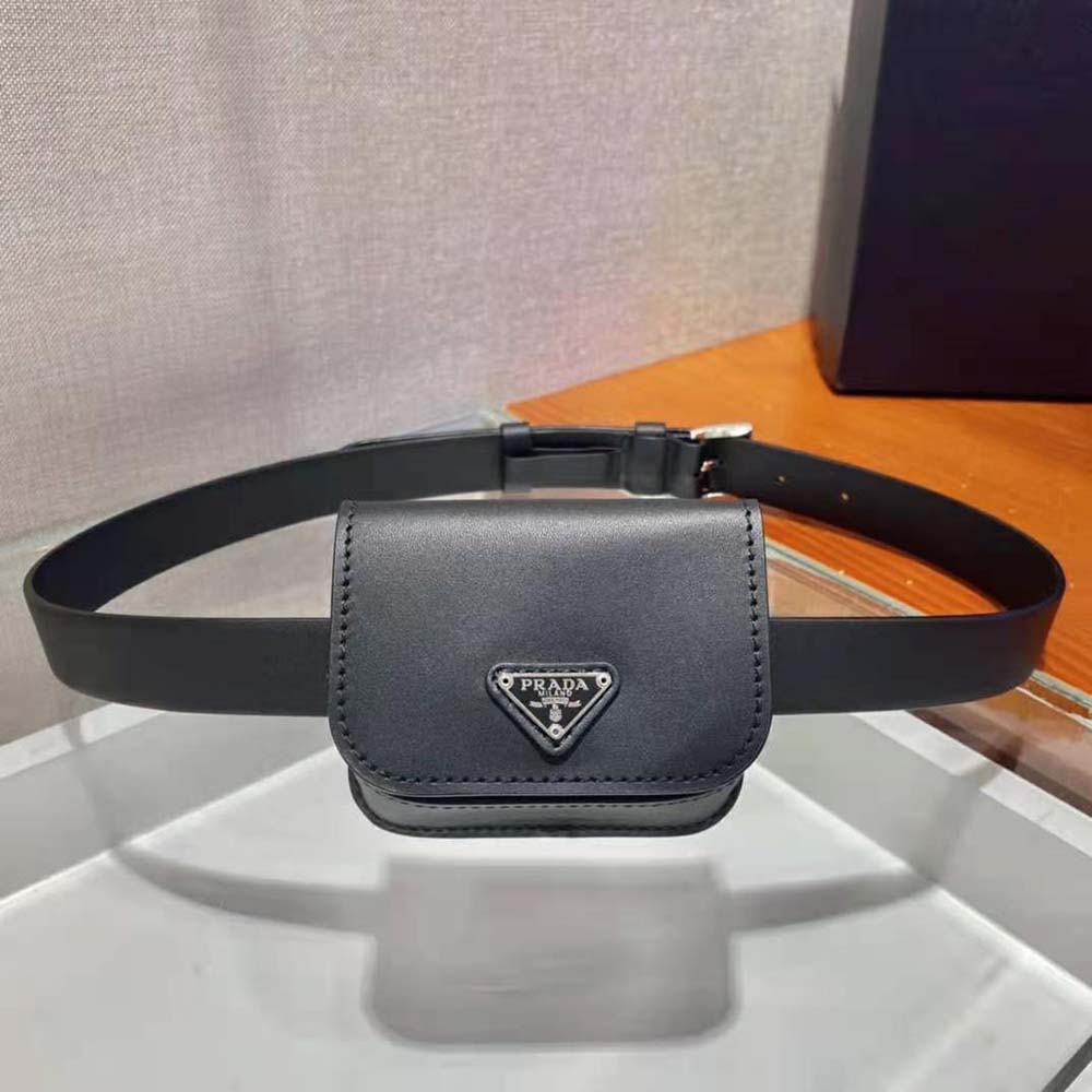 Close-up of signature Prada embossed hardware on the black leather belt