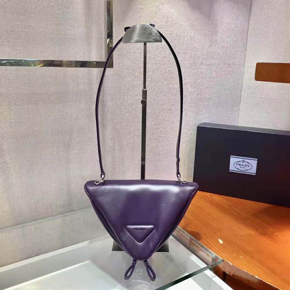 Close-up on silver Prada logo hardware on padded purple leather handbag