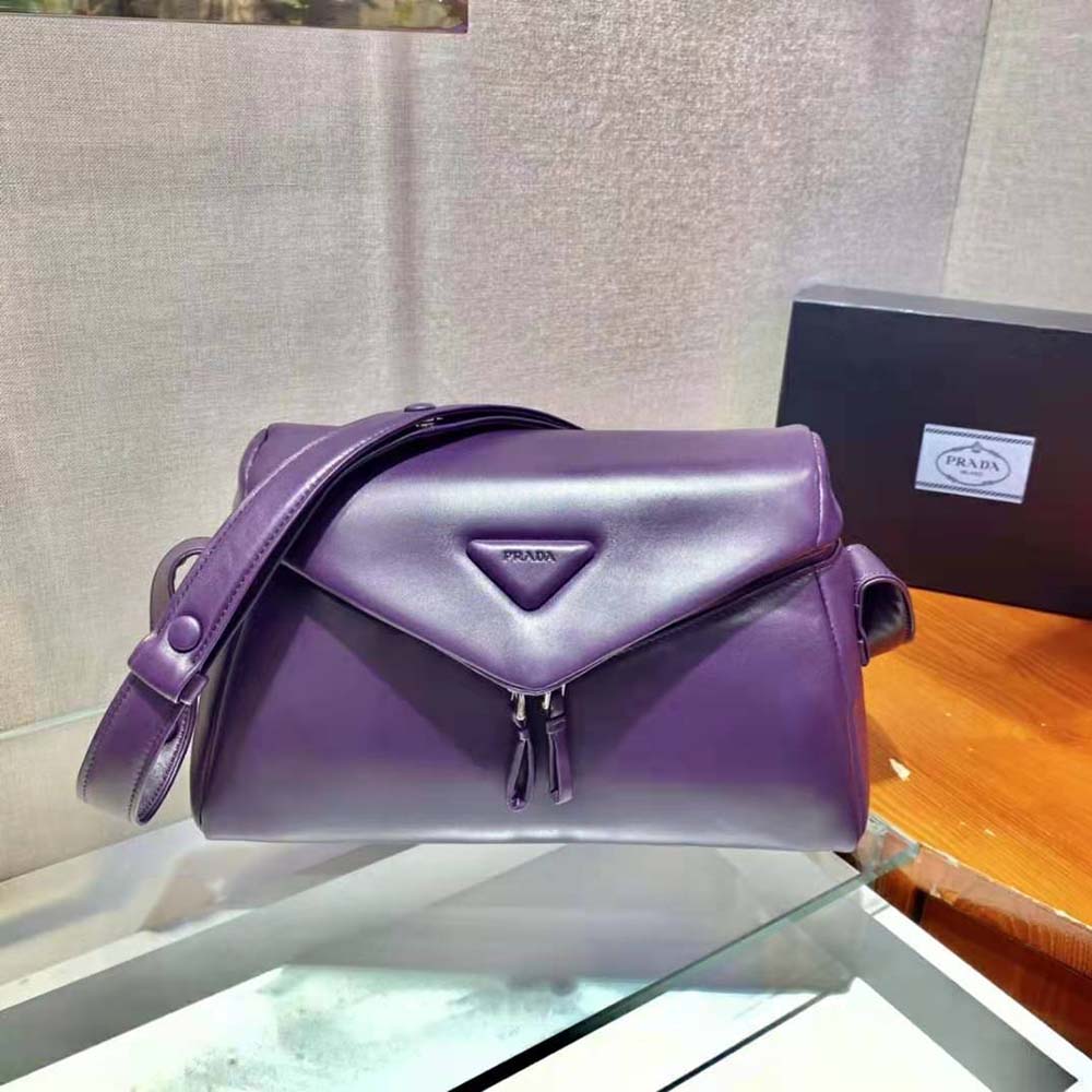 Close-up of silver-tone Prada logo hardware on purple leather bag