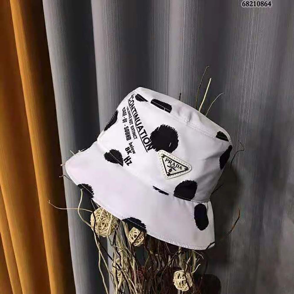 Side angle showing silver-tone logo plaque on Prada bucket hat