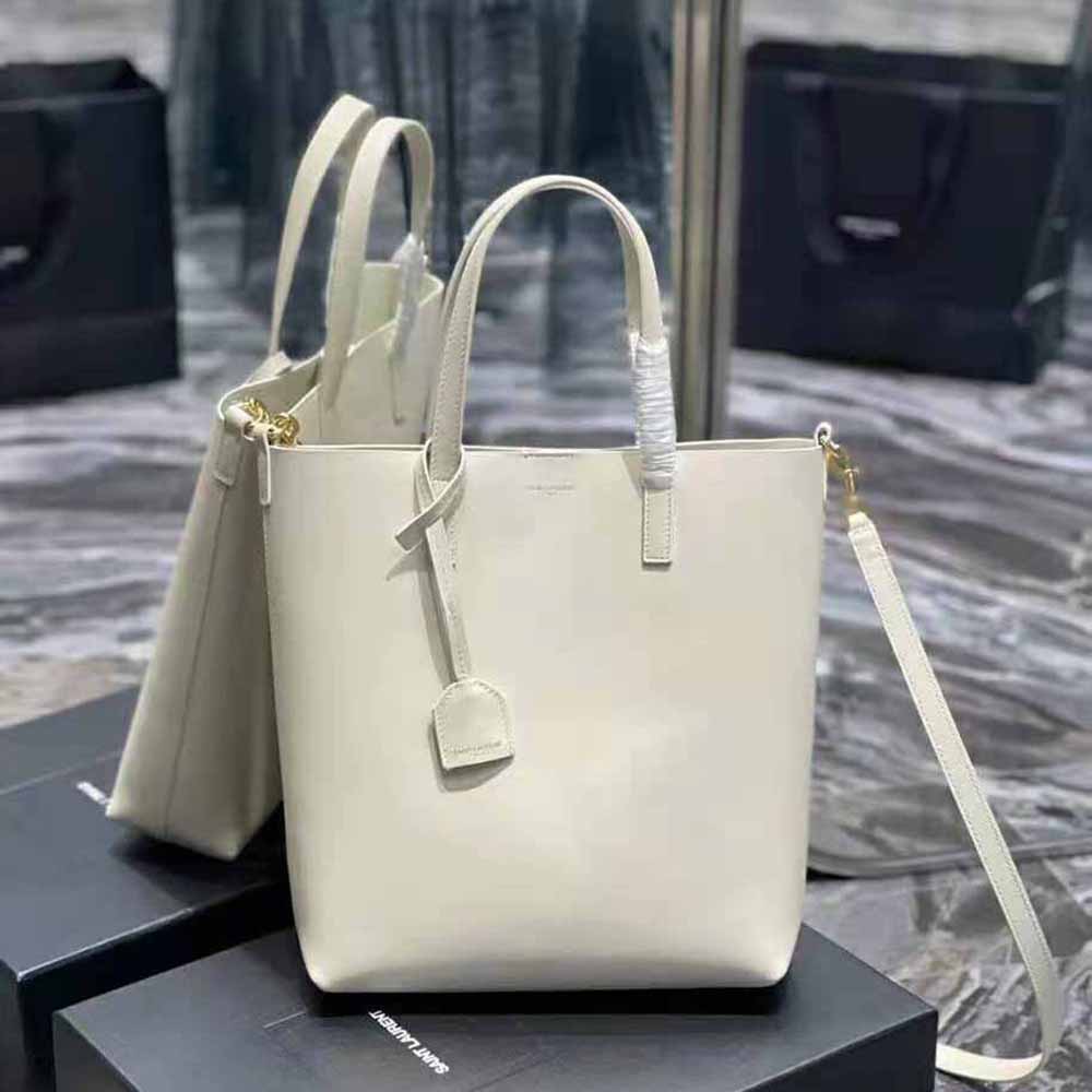 Close-up of gold YSL logo hardware on white leather Toy Shopping Bag