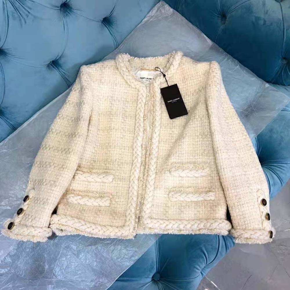 Close-up of YSL signature button on white check wool and silk tweed jacket