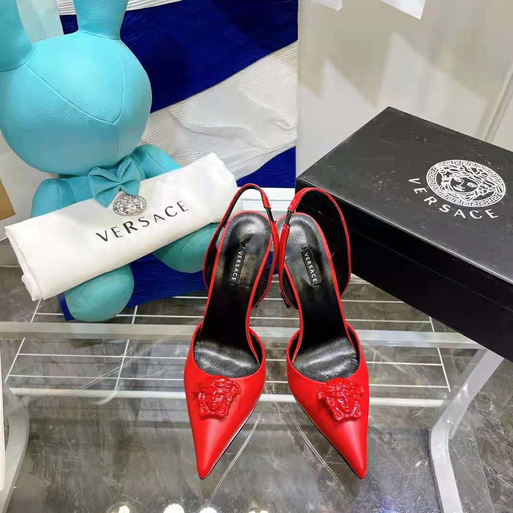 Close-up on gold Medusa hardware detail on Versace Women LA Medusa Sling-Red Pumps