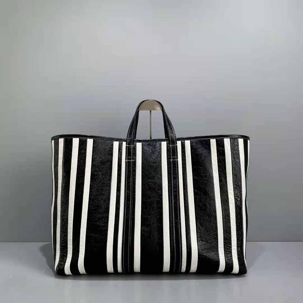 Side angle showing zip closure and leather texture of Balenciaga Women Barbes Large East-West Shopper Bag