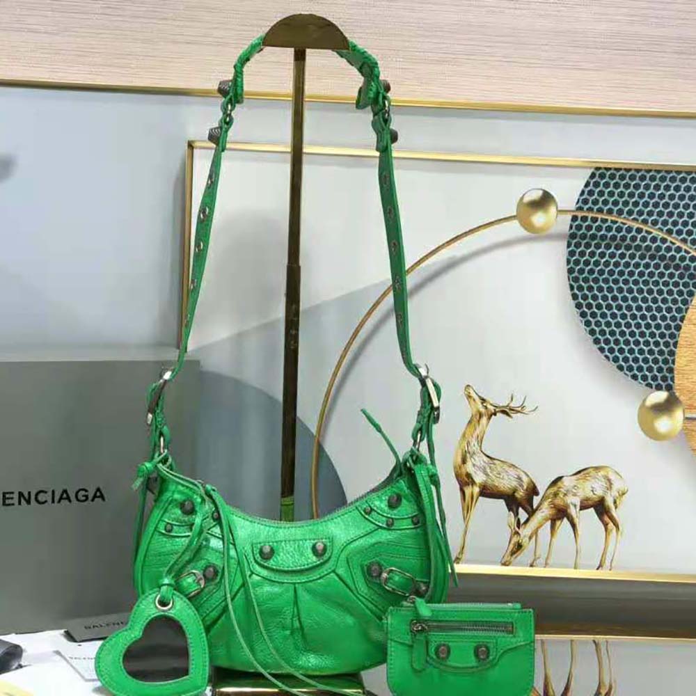 Close-up of distressed green leather and aged silver hardware on shoulder bag