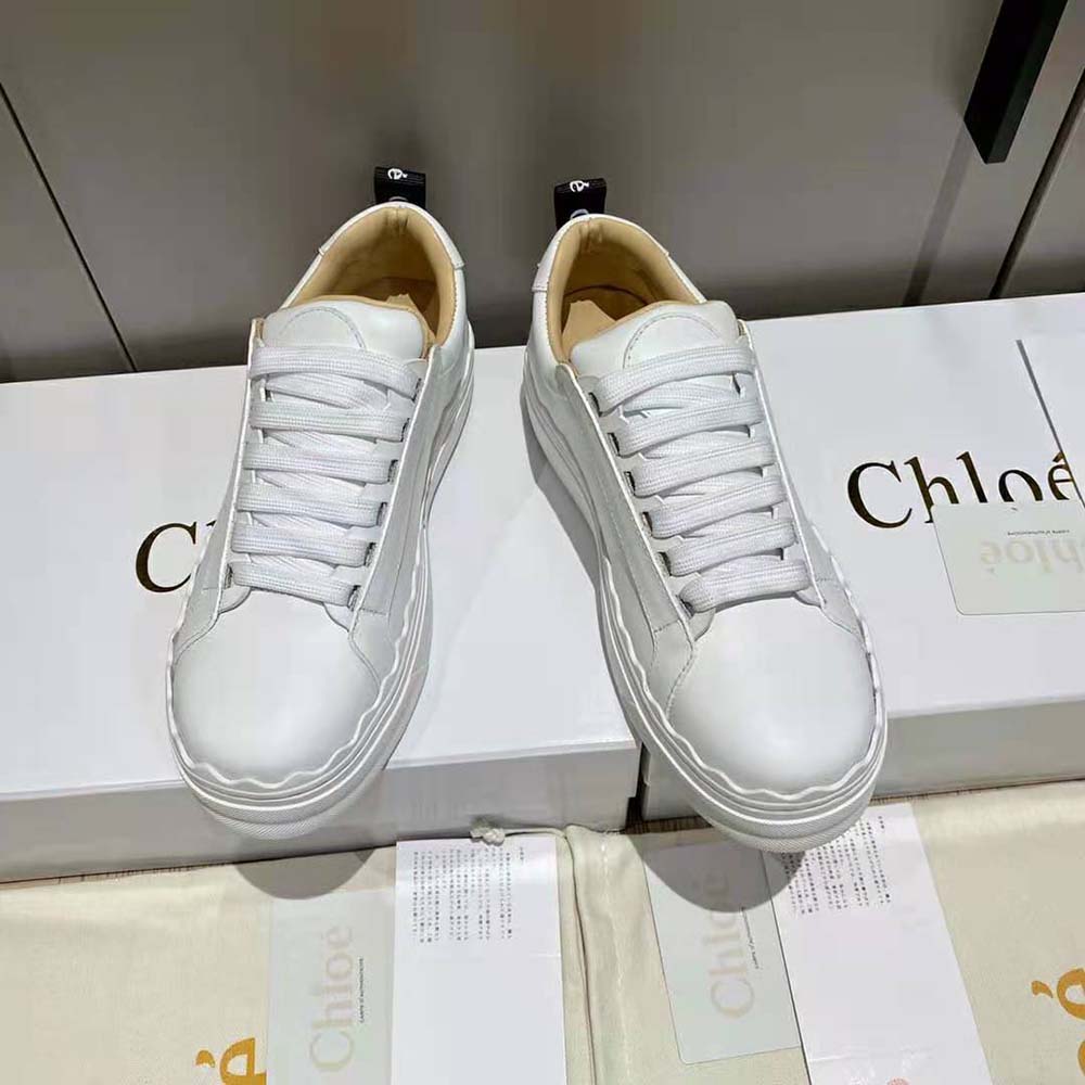 Close-up detail of gold-tone logo hardware on Chloe Lauren Sneaker