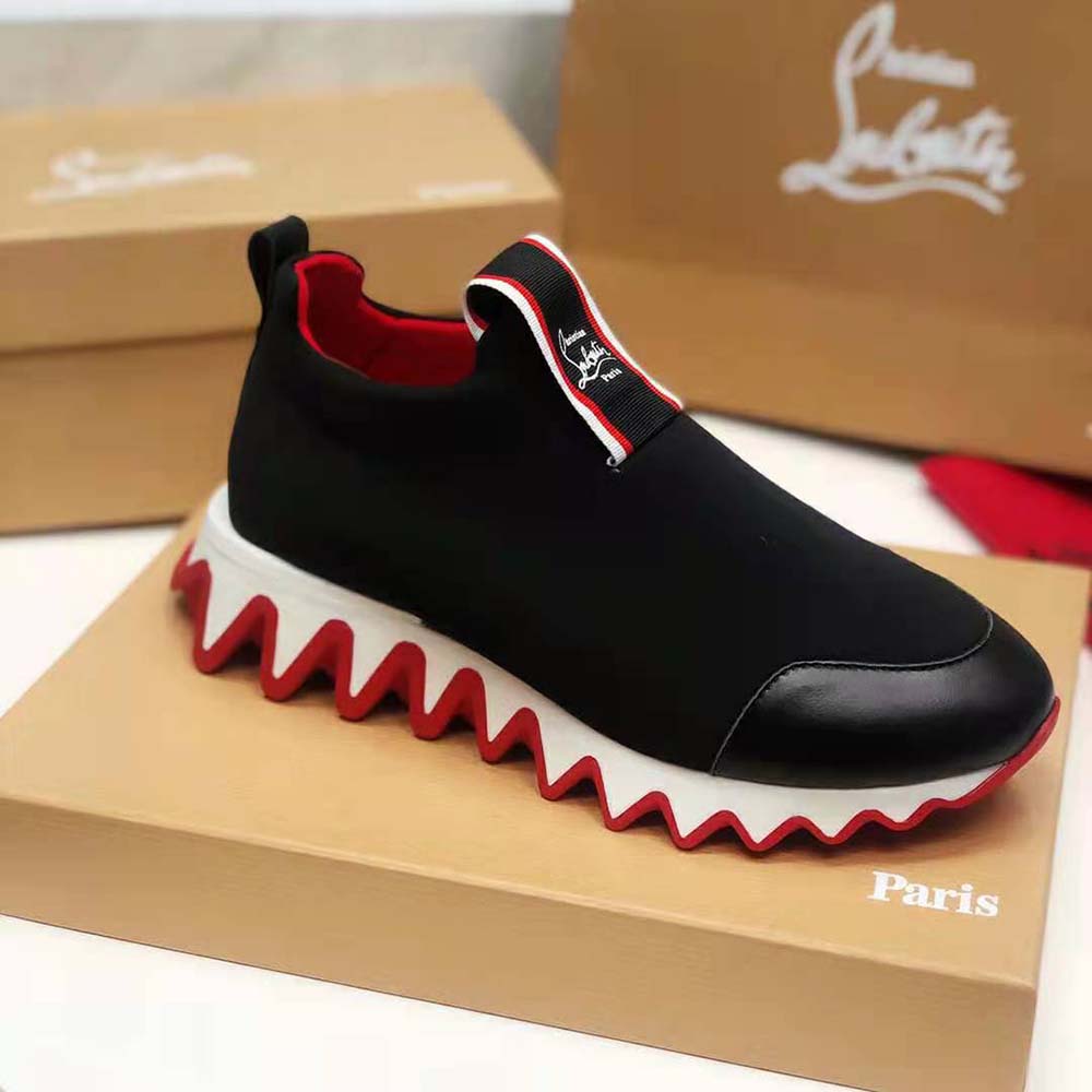 Close-up on red lacquered sole of Christian Louboutin Women Tiketa Run-Black