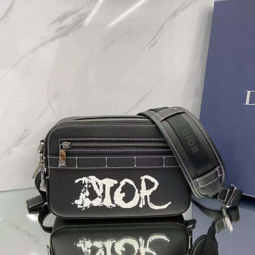 Close-up on gunmetal hardware and textured leather on Dior Men Peter Doig bag