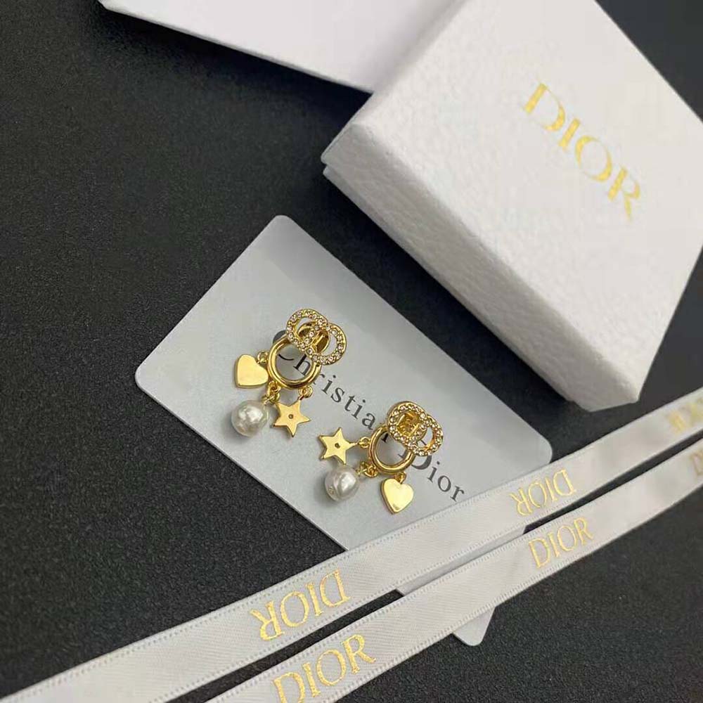 Close-up of gold-finish and celestial star detail on Dior earrings