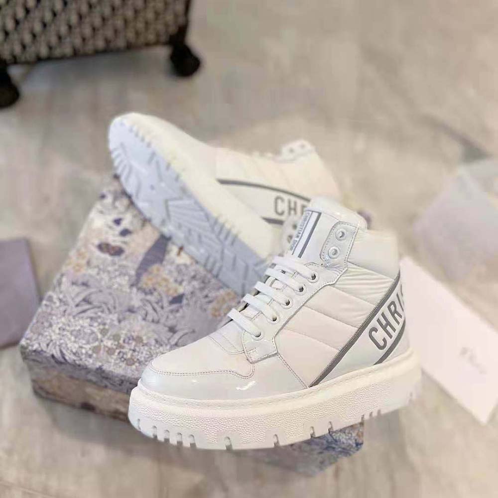 Top-down look at silver Dior logo hardware on white high-top sneaker