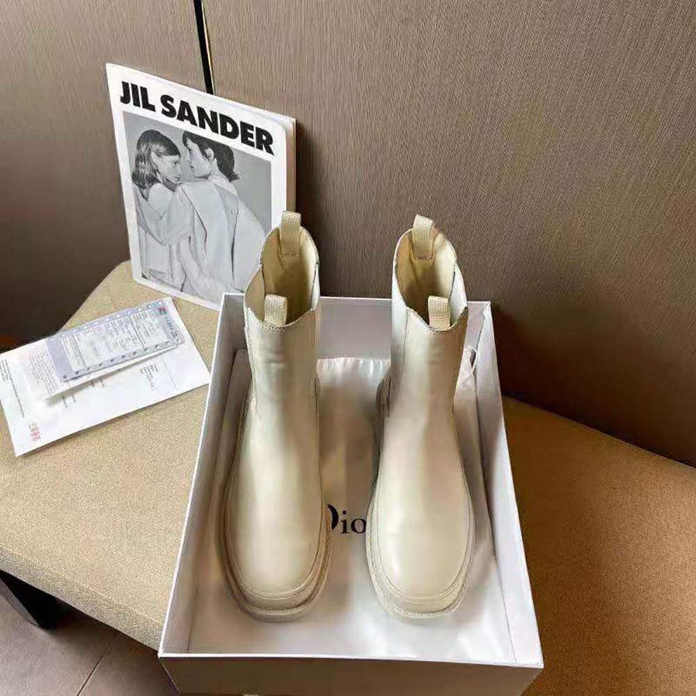 Close-up detail of white calfskin and Dior hardware on ankle boot