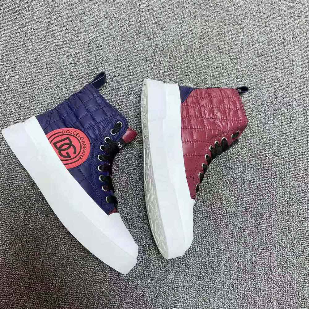 Close-up of quilted navy nylon and D&G logo hardware detail on sneakers