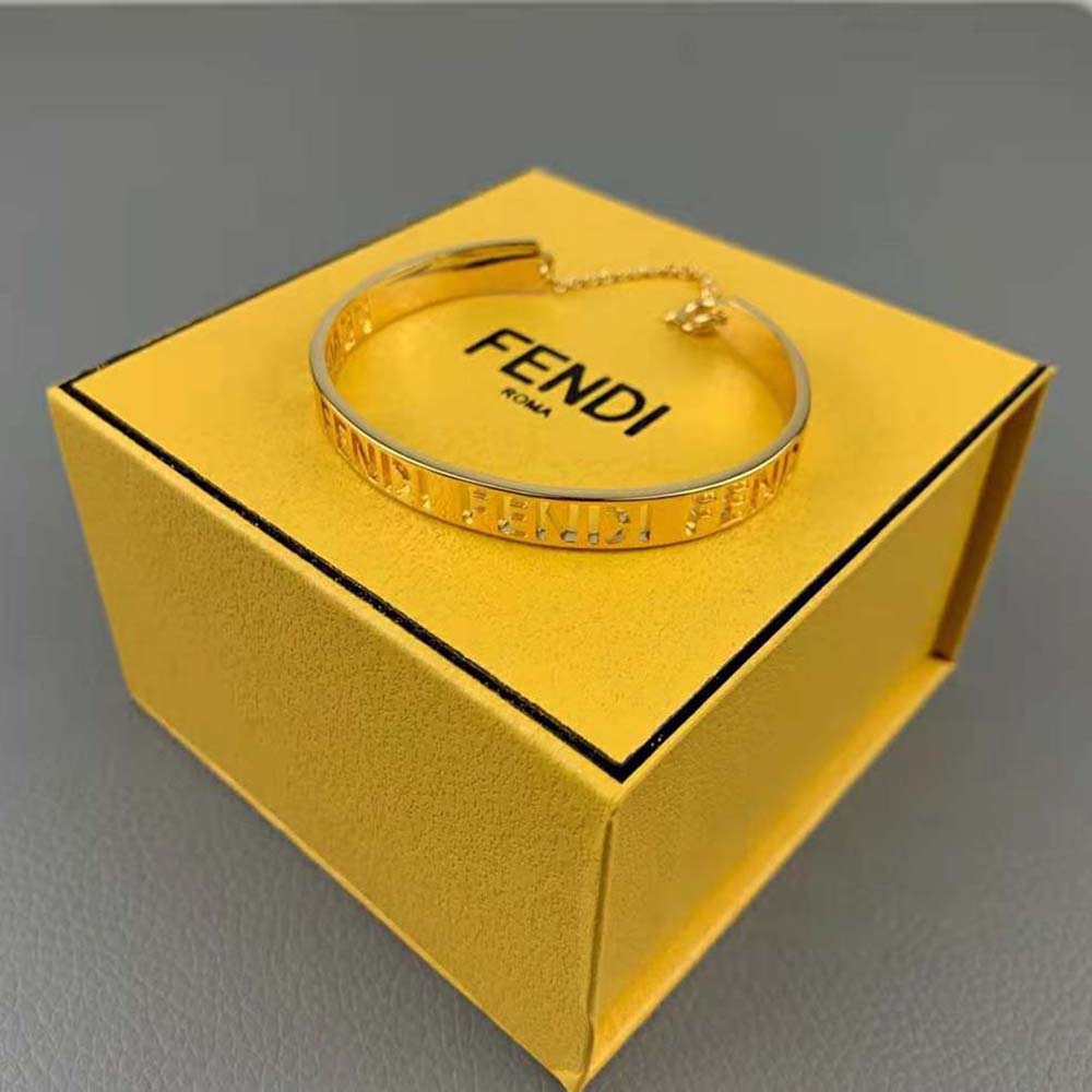 Styled Fendi Women Gold-Colored Bracelet worn on wrist with layered jewelry