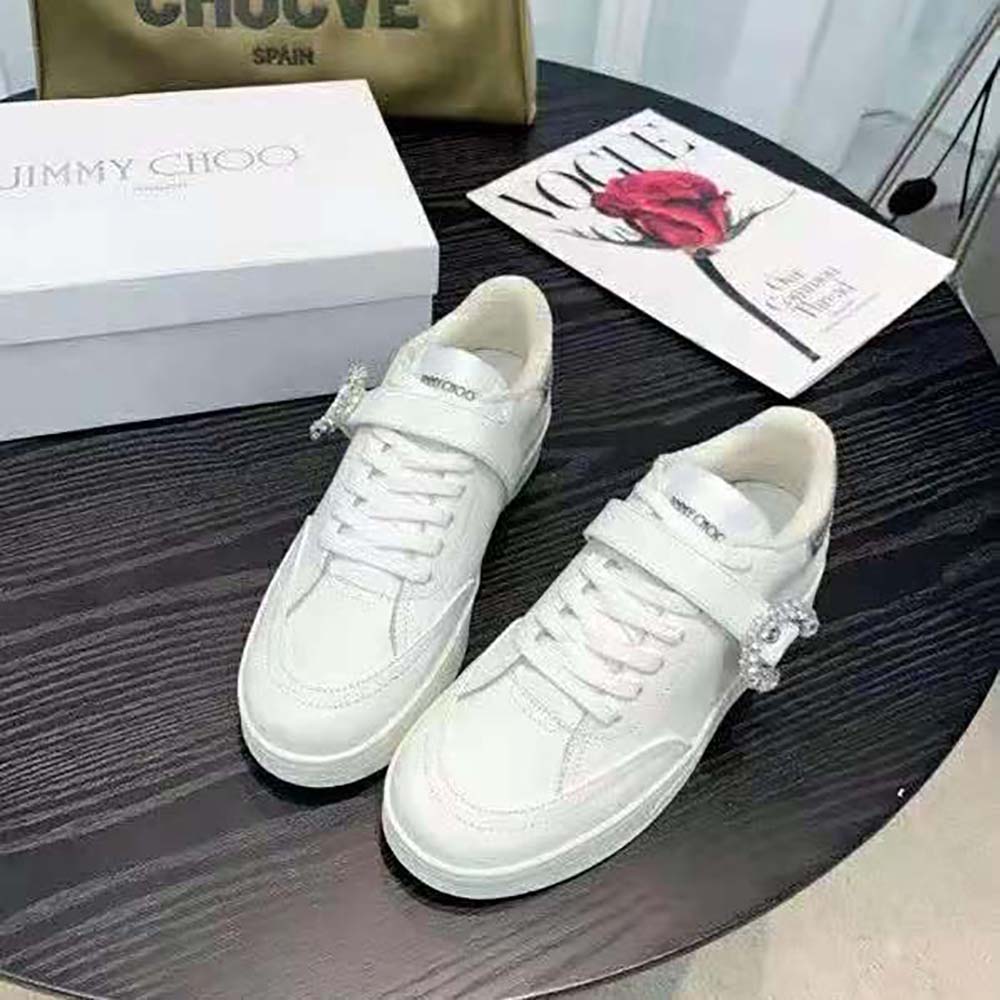 Close-up of silver metallic nappa and signature hardware on Jimmy Choo trainers
