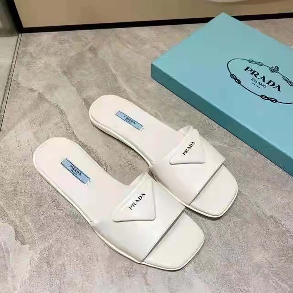 Close-up of Prada triangle logo on white leather slide