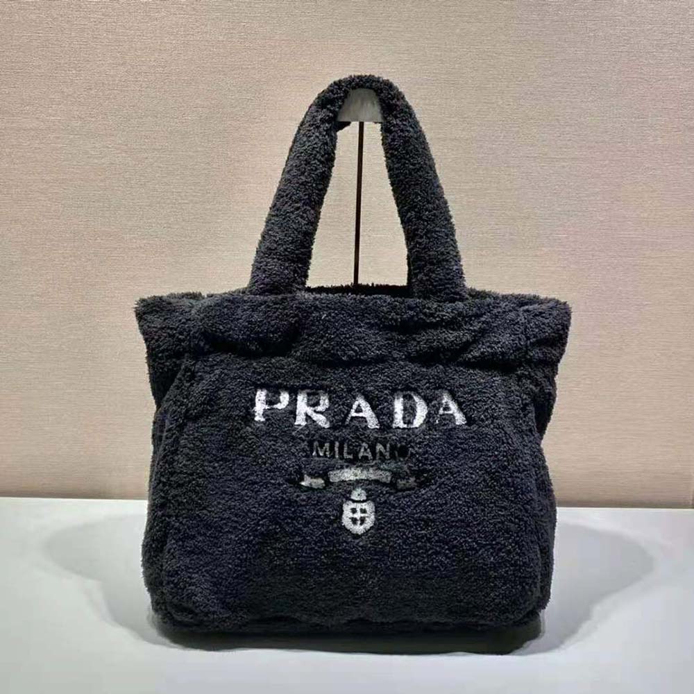 Close-up of enameled metal triangle logo on Prada terry tote bag