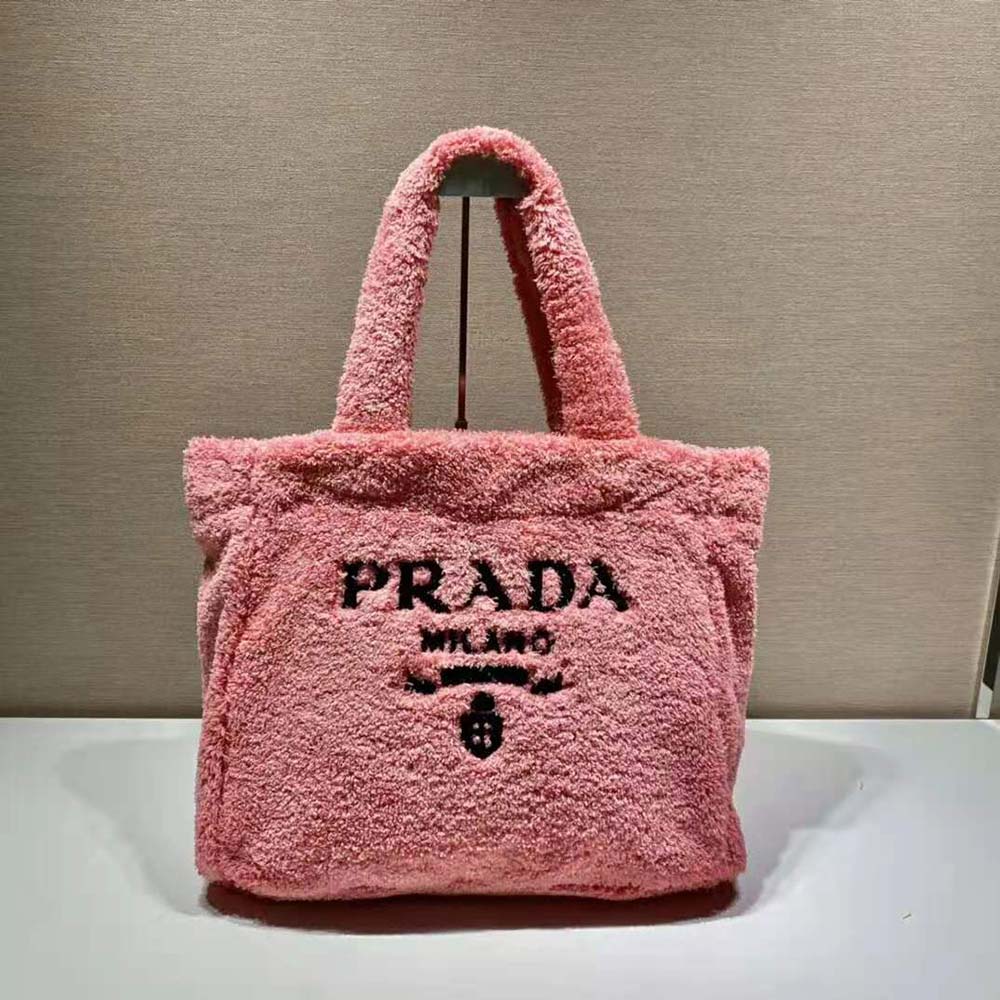 Close-up of enameled metal triangle logo on pink Prada terry tote bag