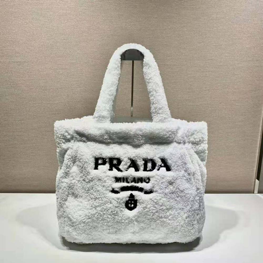 Close-up of enameled metal triangle logo on Prada White Terry Tote Bag