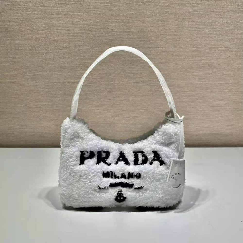 Close-up of silver triangular logo on terry fabric mini-bag