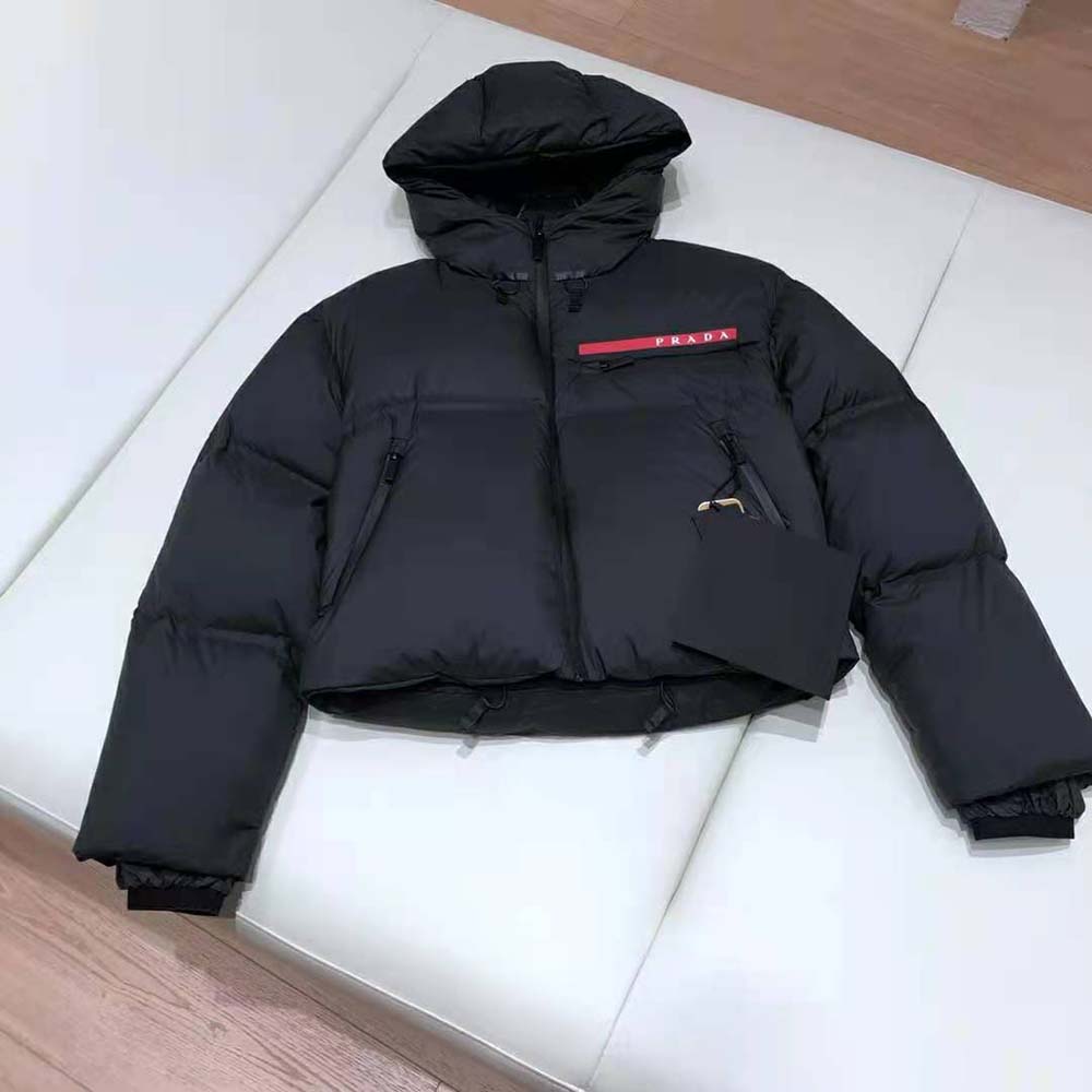 Close-up of black nylon fabric and Prada logo on jacket chest