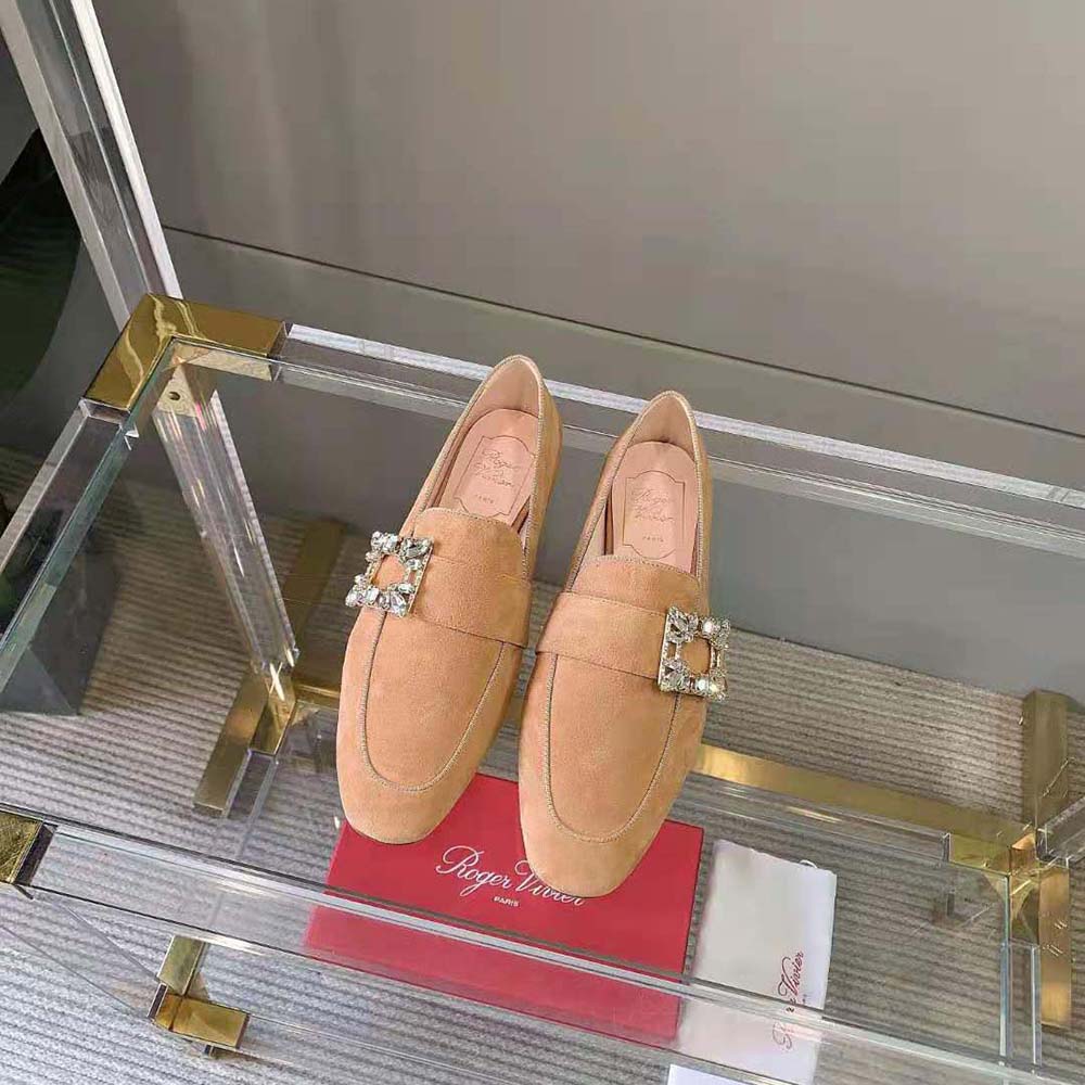 Close-up detail of beige suede and signature buckle on Roger Vivier loafers