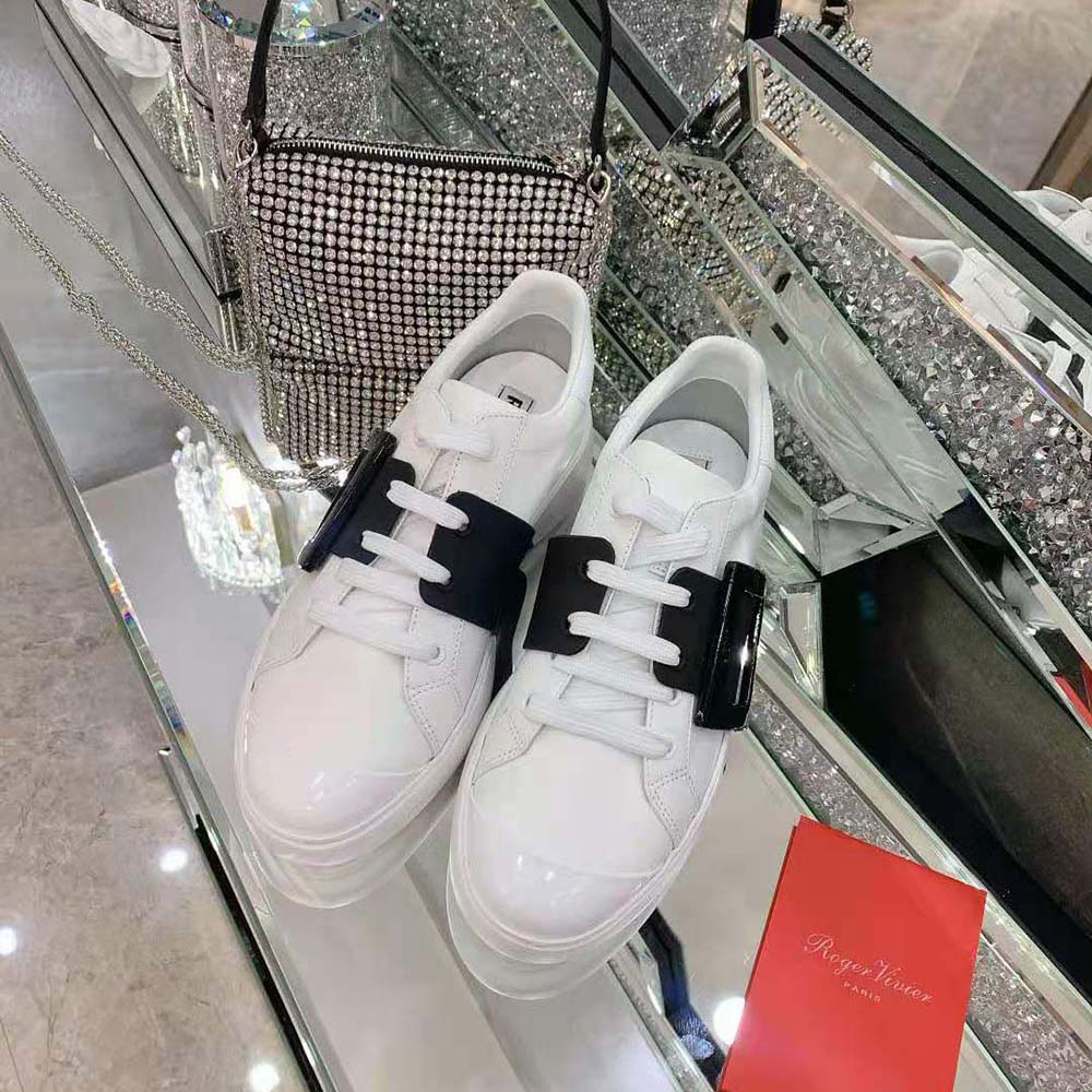 Close-up of signature buckle detail on Roger Vivier lacquered sneakers