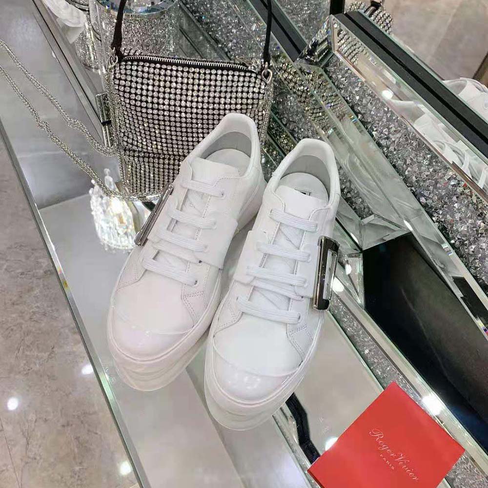 Close-up of gunmetal metal buckle on Roger Vivier white sneakers
