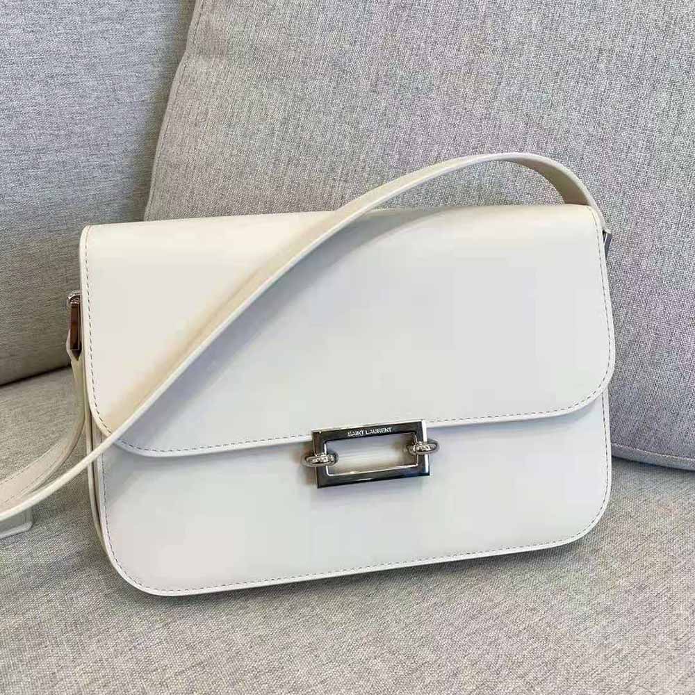 Close-up of gold-tone YSL pave hardware on white smooth leather satchel