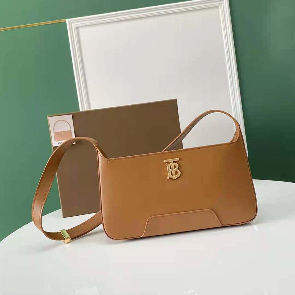 Close-up of gold TB hardware on brown leather shoulder bag