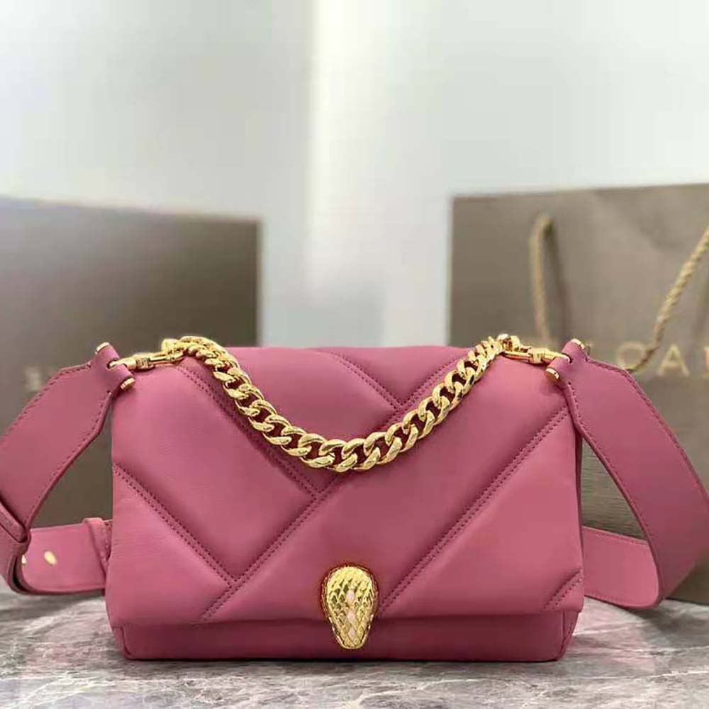 Close-up of gold-tone serpent head hardware on pink Bvlgari crossbody bag