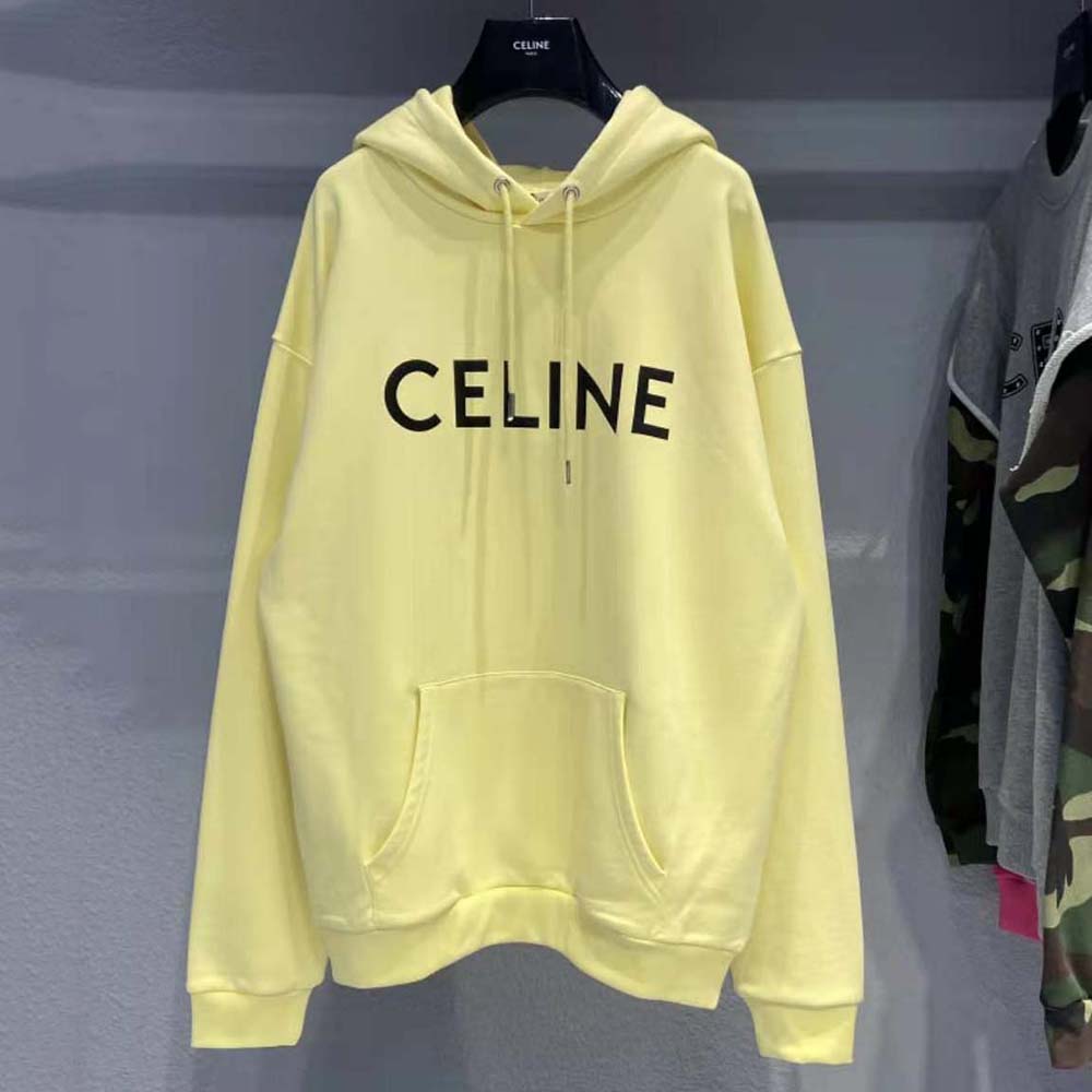 Close-up of soft cotton fabric and embossed logo on yellow sweatshirt