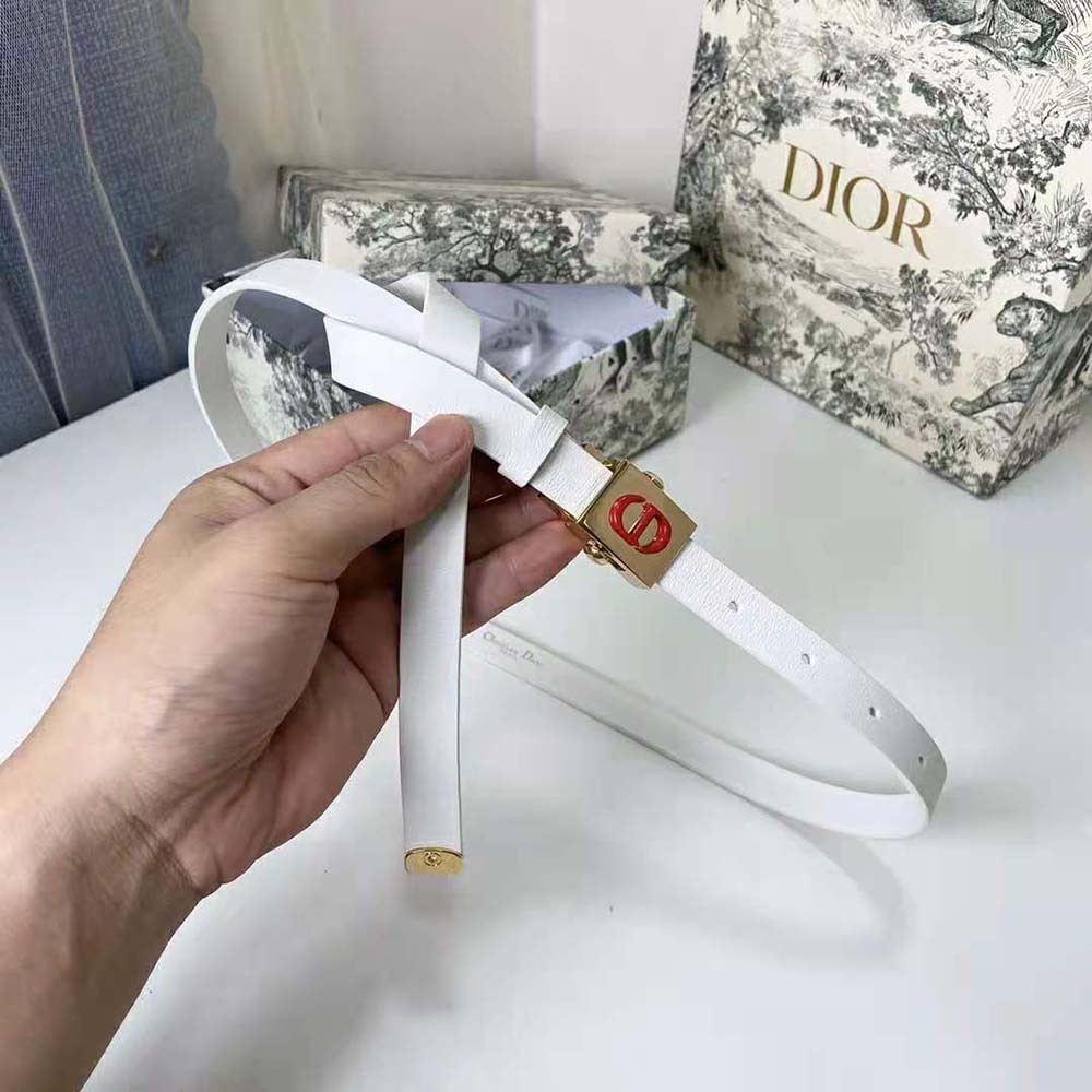 Close-up on signature Dior metal hardware on white belt