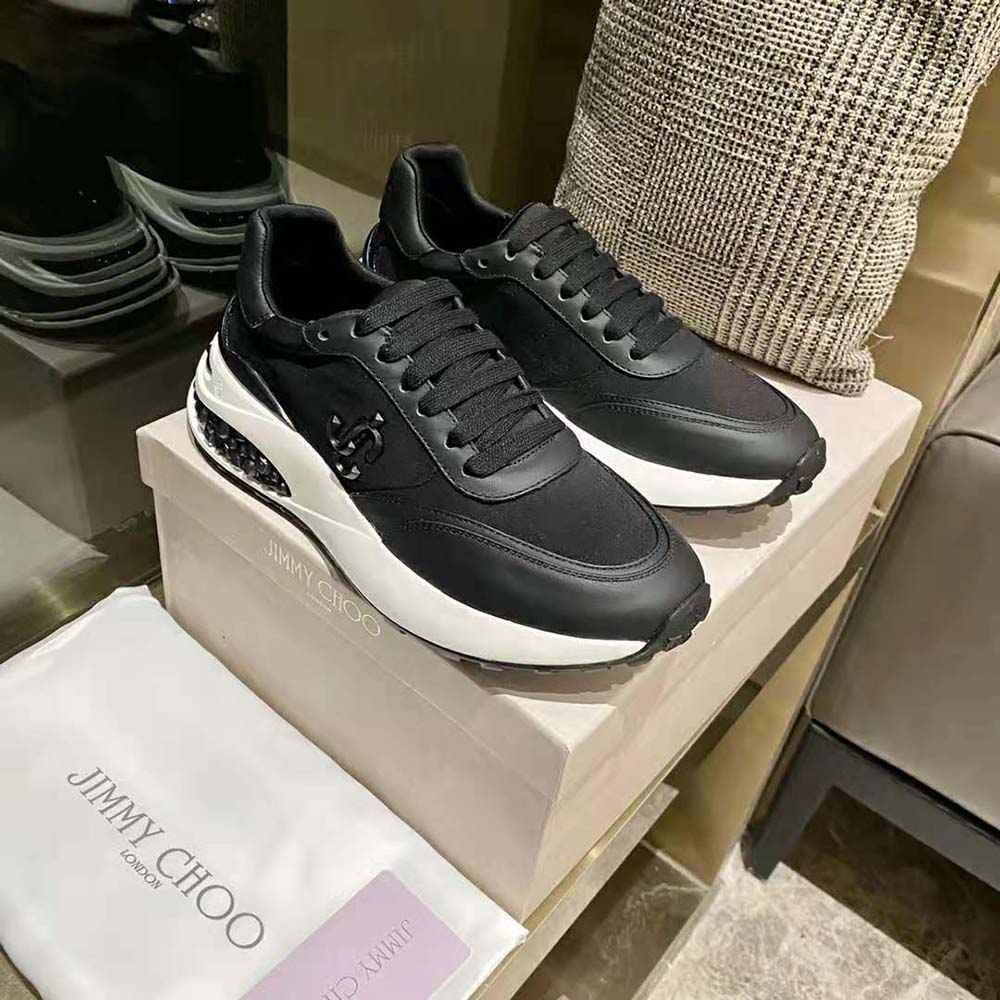 Top angle showing black neoprene and leather texture on Jimmy Choo trainers