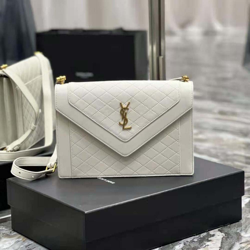 Close-up of gold YSL logo and white lambskin quilting on Gaby Satchel