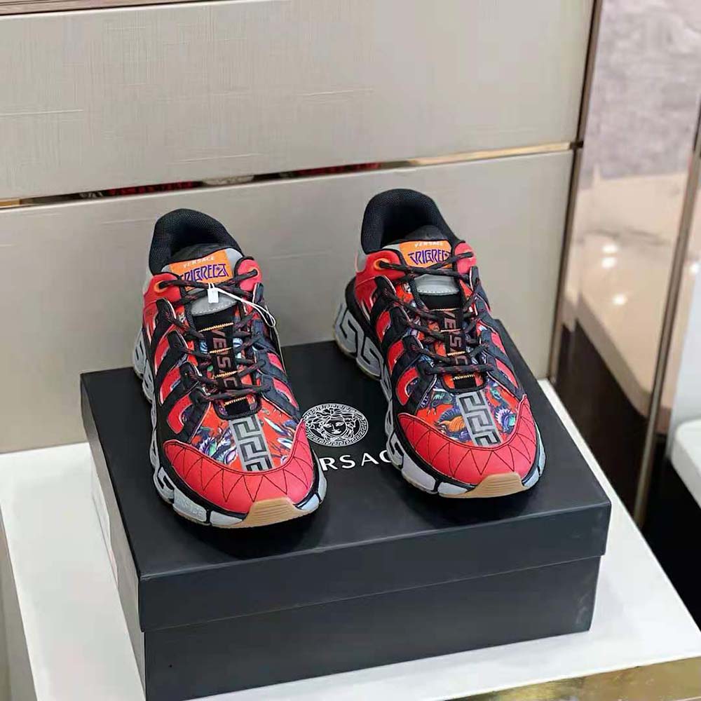 Close-up of gold Trigreca logo hardware on Versace Women Trigreca Coveted Sneaker Family-Red