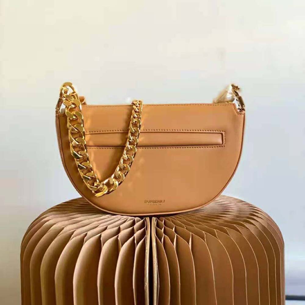 Side profile of Burberry Women Mini Leather Zip Olympia Bag-Brown highlighting smooth beige leather