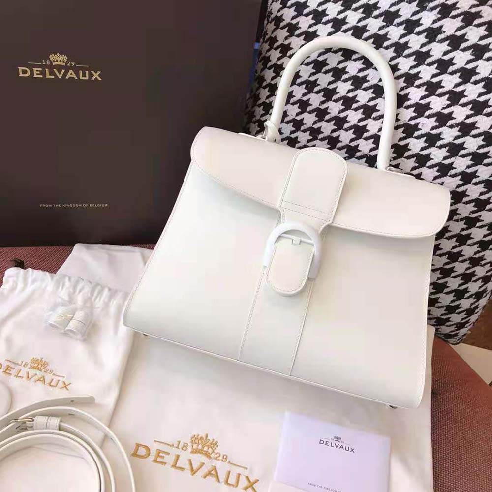 Side angle showing structured silhouette of Delvaux Women Brillant MM white bag